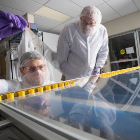 技术人员在实验室的大桌子上使用玻璃